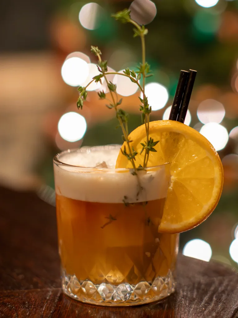 Picture yourself in a cozy, festive setting, surrounded by the warm glow of holiday lights. In your hand, you hold a Clementine and Disaronno Sour Cocktail, a drink that perfectly captures the spirit of the season.