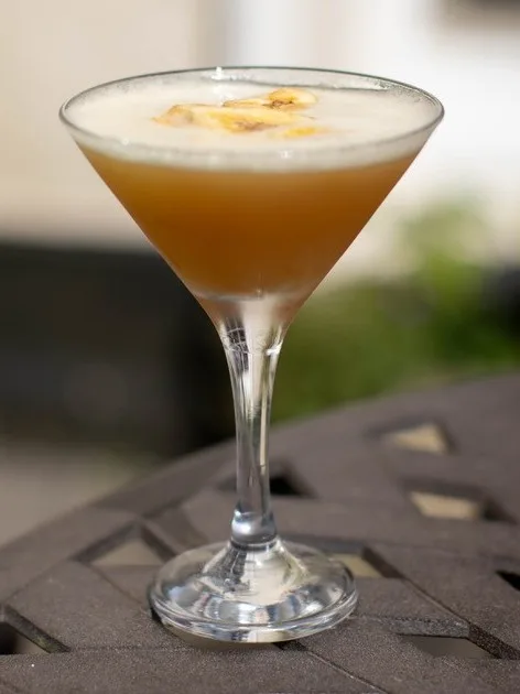 Imagine a Banana Daiquiri cocktail that arrives, vibrant and inviting, crowned with a glistening, golden-brown caramelised banana slice and a fresh sprig of mint.