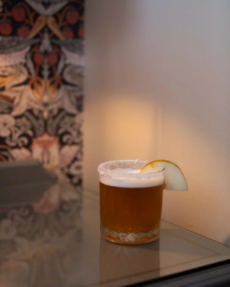 Pear Crumble Whiskey Sour Cocktail - A dessert-inspired whiskey sour built on pear and apple: warm blended whiskey, marzipan-sweet amaretto, ripe pear and orchard apple, cinnamon-spiced foam, finishing rich, cosy and crumble-like.